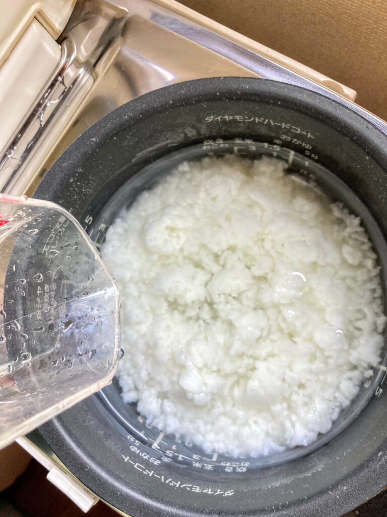 お粥に水いれる